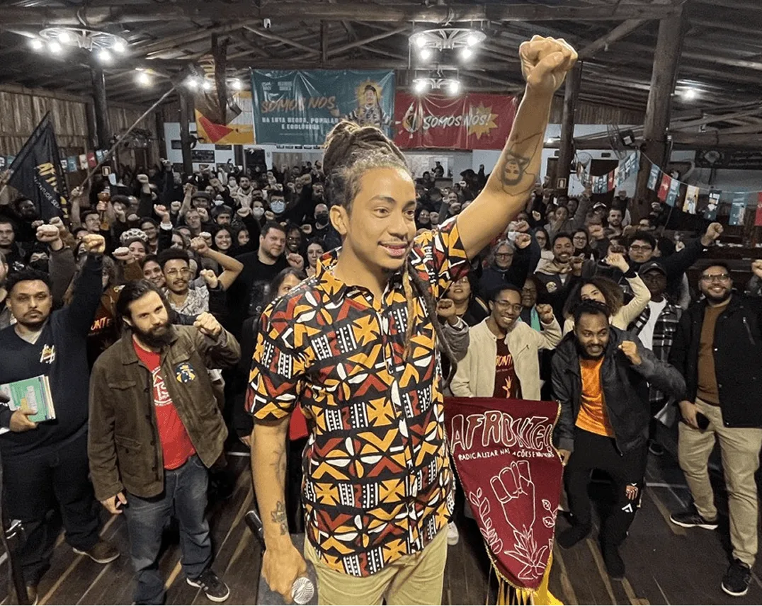 Matheus Gomes de punho erguido em ato lotado com apoiadores